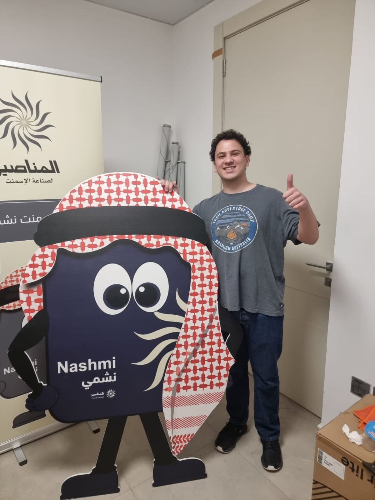 Scale check: life-size standee, mascot, shemagh lockup, pull-up.