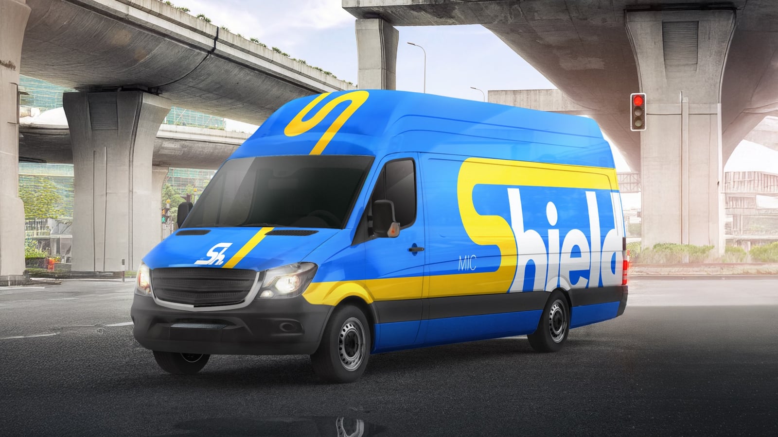 Shield branded delivery van with large side graphics under an overpass